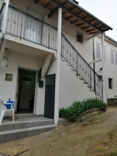 a white house with a balcony and a door at As três irmãs in Bragança