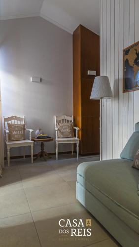 a bedroom with a bed and two chairs and a table at Casa Dos Reis - Boutique Hostel in Angra do Heroísmo