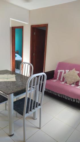 a living room with a table and a purple couch at Cantinho Xodó in Capitólio