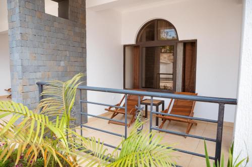 a balcony with two chairs and a table at Ndaru Luxury Suites in Kigali