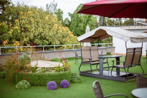 a patio with chairs and a table and an umbrella at Ndaru Luxury Suites in Kigali