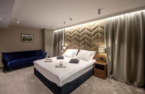 a bedroom with a large bed and a blue couch at Hotel Turist in Varaždin