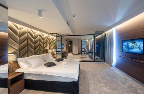 a bedroom with a large bed and a flat screen tv at Hotel Turist in Varaždin