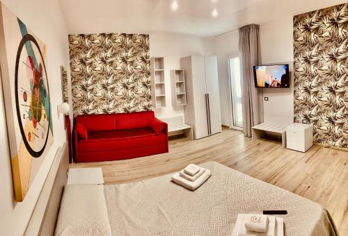 uma sala de estar com um sofá vermelho e uma televisão em Bonaventura em Porto Cesareo