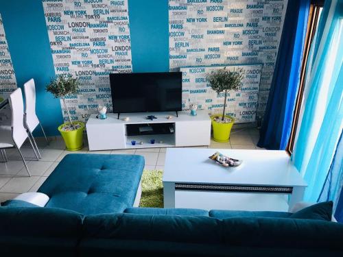 een woonkamer met een blauwe bank en een tv bij THE VIEW APARTMENT KAVALA in Kavala