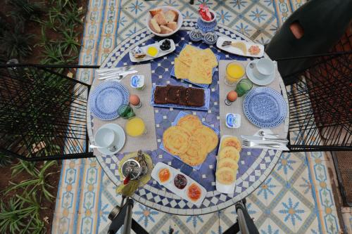 a table with breakfast foods on a blue and white plate at Riad Catalina in Marrakech