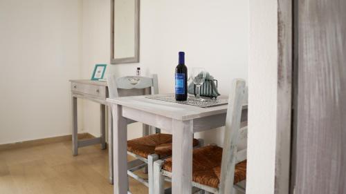 a white table with a bottle of wine on it at Pittas Studios in Kardamaina