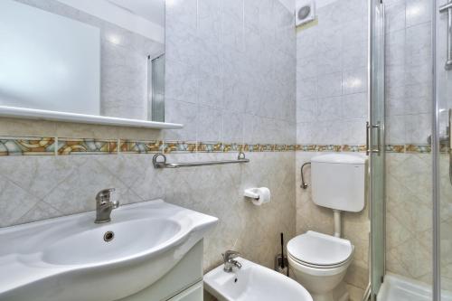 Baño blanco con lavabo y aseo en InBlue en Savudrija