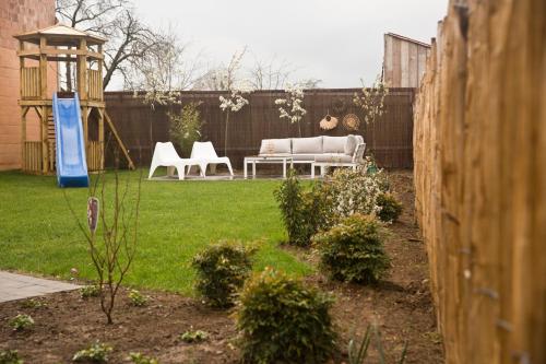 a garden with a couch and chairs in a backyard at Vakantiewoning Spoor 23 in Borgloon