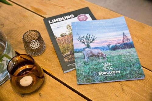 a table topped with a magazine and a book with a cow at Vakantiewoning Spoor 23 in Borgloon
