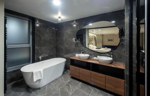 a bathroom with two sinks and a large mirror at Hotel Turist in Varaždin