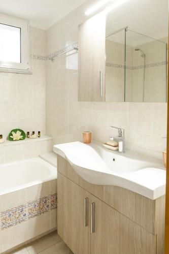 a bathroom with a white sink and a tub and a bath tub at Chrysa House Kissamos in Kissamos