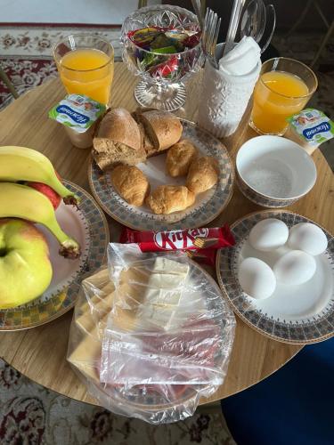 een houten tafel met borden eten en fruit bij Samal-2 Hotel in Alma-Ata