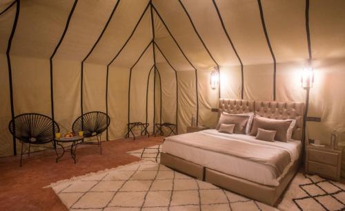 a bedroom with a bed in a tent at Luxury Desert Camp Amanar in Merzouga