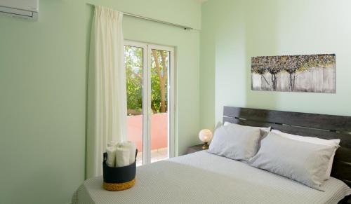 a bedroom with a bed with white sheets and a window at Kalliope in Milatos