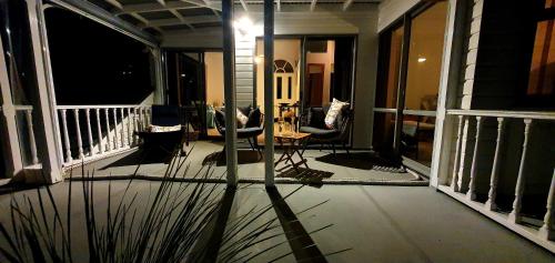 a screened in porch with chairs and a table at Paradise on The Strand in Russell