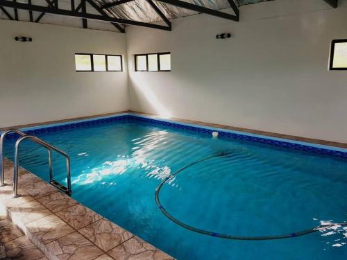 a large indoor swimming pool with blue water at 8sIndoor indoor pool4 bedroom villaGreat view and backup power in Clarens
