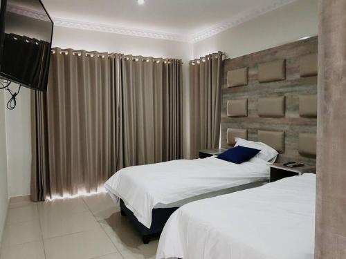 ein Hotelzimmer mit 2 Betten und einem TV in der Unterkunft 8sIndoor indoor pool4 bedroom villaGreat view and backup power in Clarens