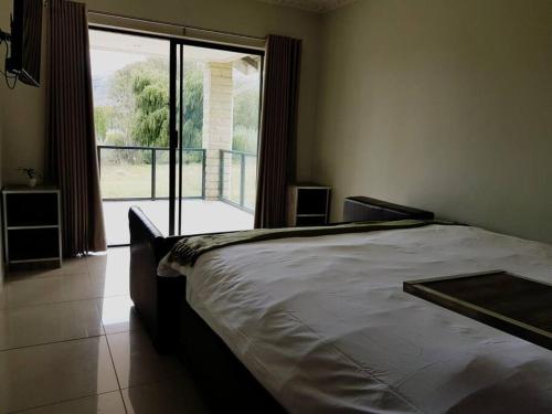 a bedroom with a bed and a large window at 8sIndoor indoor pool4 bedroom villaGreat view and backup power in Clarens