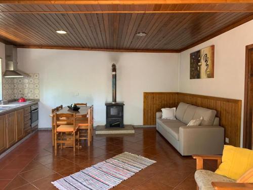 a living room with a couch and a table and a stove at Casa do Bairro Alto in Cerva