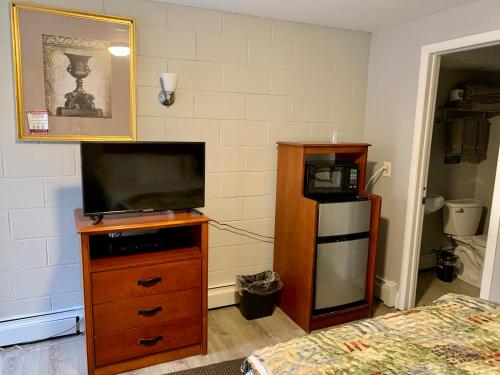 um quarto com uma televisão numa cómoda e uma cama em Hill Top Motel em Wrightstown