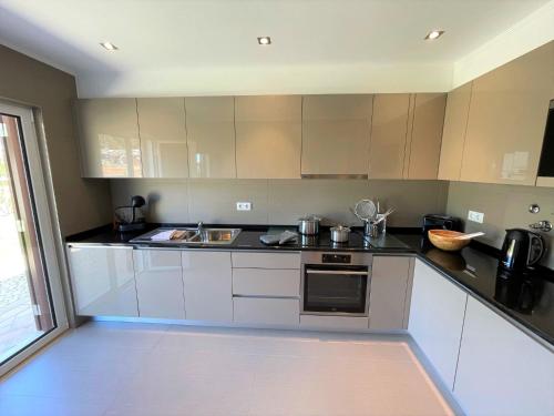 a kitchen with white cabinets and a black counter top at Villa Cascata, 3 bedroom, Pool, close to Olhos de Agua in Albufeira