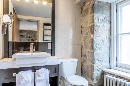 a bathroom with a sink and a toilet at Hotel Maison du Général in Quebec City