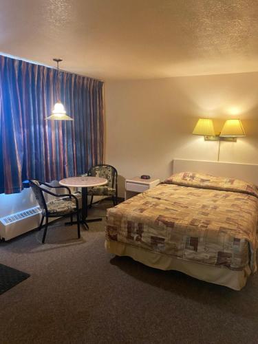 een hotelkamer met een bed en een tafel bij Chinook Motel in Lethbridge