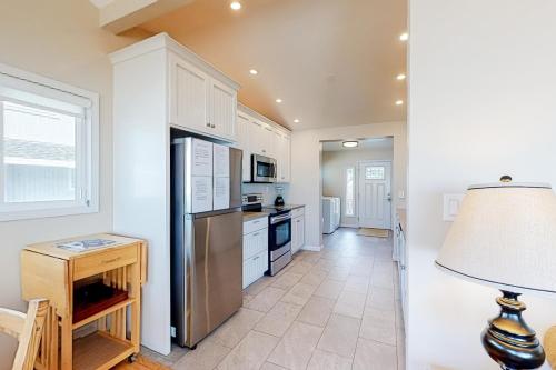 a kitchen with a refrigerator and a table with a lamp at Rockin' Away Beach House in Rockaway Beach