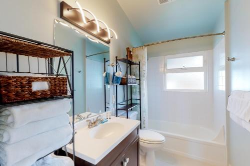 a bathroom with a sink and a toilet and a shower at Rockin' Away Beach House in Rockaway Beach