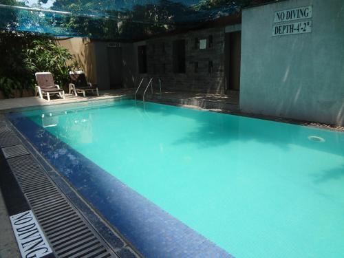 a large swimming pool with blue water at Pride Plaza Hotel, Ahmedabad in Ahmedabad