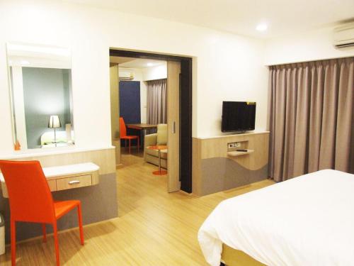 a hotel room with a bed and a television at Grand Tower Inn Sathorn Hotel in Bangkok