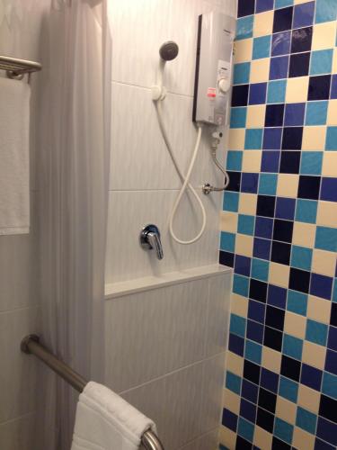 a bathroom with a shower with a toilet and a sink at Grand Tower Inn Sathorn Hotel in Bangkok