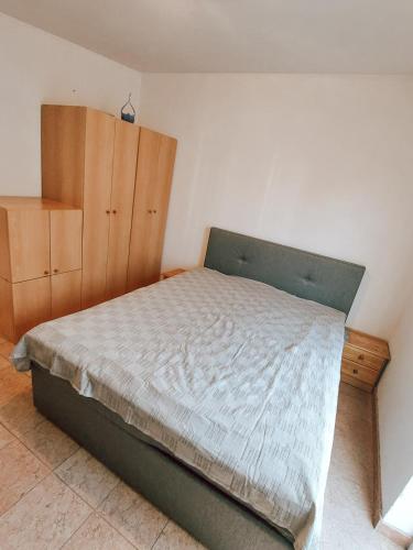 a bedroom with a bed and a wooden cabinet at House Lemon in Porat