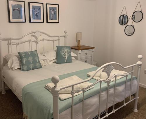 - une chambre dotée d'un lit blanc avec des draps et des oreillers verts dans l'établissement Seawards 2 bedroomed Seafront Filey, à Filey