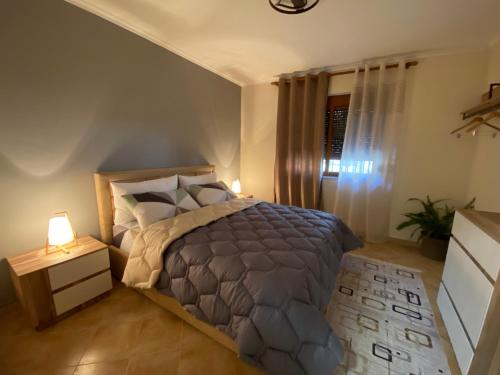 a bedroom with a bed and a night stand with a lamp at Lucas Apartment 2 in Tirana