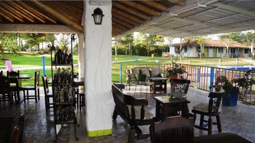 a group of tables and chairs under a pavilion at Finca Hotel los Nogales in Quimbaya