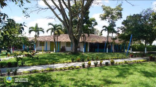 a house with a tree in the yard at Finca Hotel los Nogales in Quimbaya