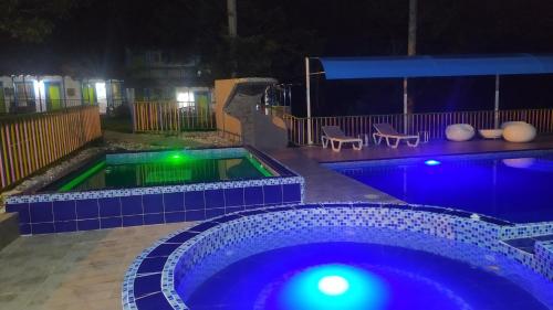 a swimming pool at night with blue lights at Finca Hotel los Nogales in Quimbaya