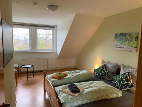 a bedroom with two beds and a table and a window at Ferienwohnung Buchenblick in Kassel