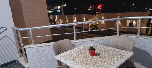 a table and chairs on a balcony with a view of a city at Vacation Station sea view apartament in Vlorë