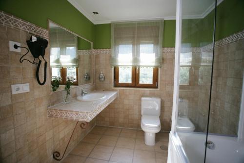 a bathroom with a toilet and a sink and a shower at Posada El Corcal de Liébana in Tama