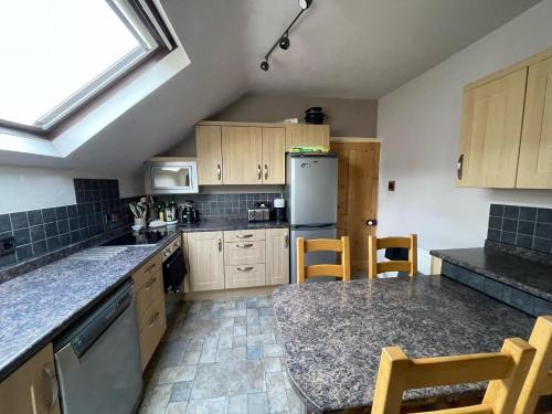 a kitchen with wooden cabinets and a refrigerator at Seaside Rentals Bournemouth - cosy 2BR, 4-6ppl, beach 5 min walk, park 2 cars, fast WiFi in Bournemouth