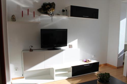 - un salon avec une télévision sur un mur blanc dans l'établissement El Refugio, à Calatayud