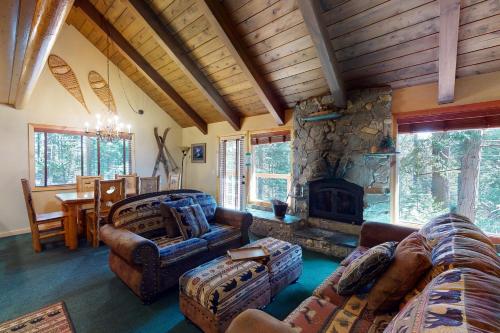 a living room with couches and a stone fireplace at Yosemite Silvertip Lodge in Fish Camp