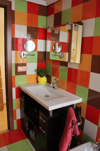 a bathroom with a sink and a colorful wall at El Refugio in Calatayud