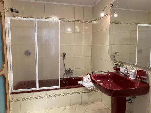 La salle de bains est pourvue d'un lavabo rouge et d'une douche. dans l'établissement Casa di Angela, à Chioggia