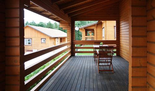 a porch of a cabin with a table and chairs at Jeju I've Hotel & Resort in Seogwipo