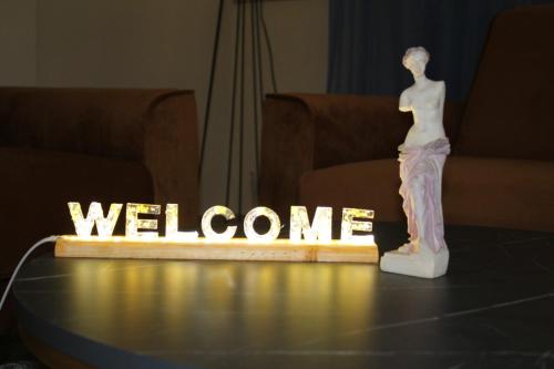 a mannequin standing on a table with a welcome sign at Hotel Ambasador Garden in Lezhë