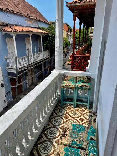 a balcony with two chairs sitting on a tiled floor at Hostal Badillo SV in Cartagena de Indias